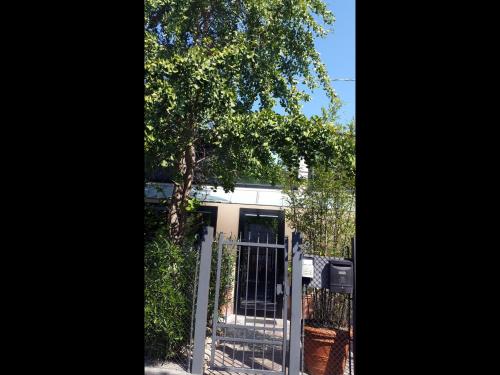 a gate in front of a house with a tree at A Casa in Ravenna