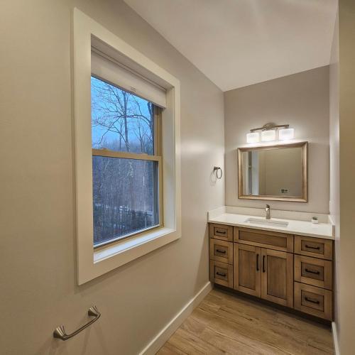 Powder Run - Modern 3BR Basecamp with Hot Tub, AC, EV Charger & Flat Parking في North Sherburne: حمام مع حوض ونافذة