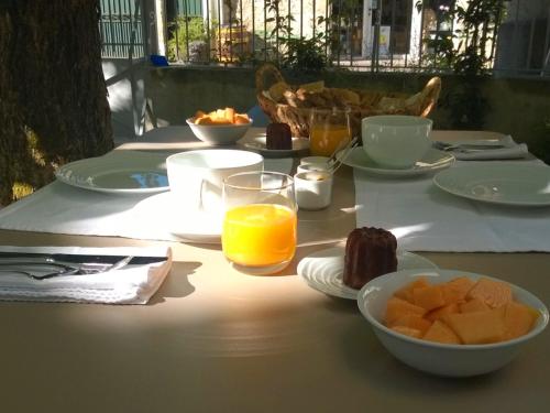 a table with a bowl of fruit and a glass of orange juice at La Sauternaise, luxury Boutique B&B in Sauternes