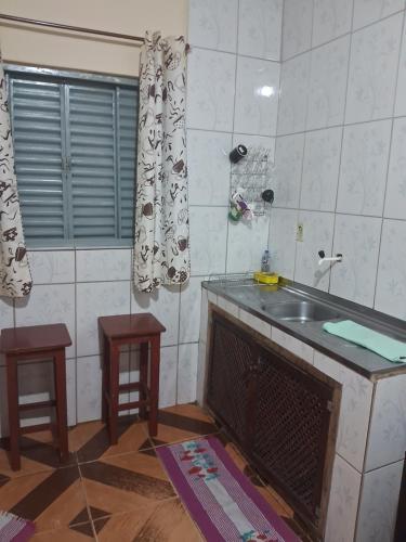 a kitchen with a sink and a fireplace in a room at Recanto feliz in São Thomé das Letras