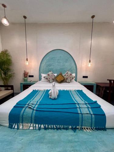 a large bed with a teddy bear sitting on it at Chique Shanti Villa in Mandrem