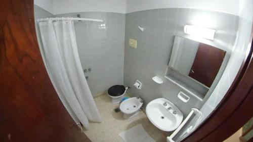 a bathroom with a sink and a toilet and a mirror at Hostería Bavaria por Las Grullas in Villa Gesell