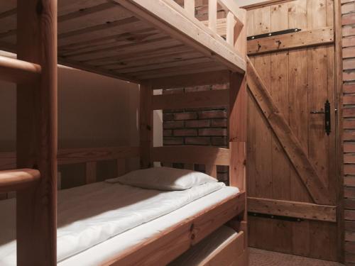 Ce lit superposé se trouve dans un dortoir doté de murs en bois. dans l'établissement Agroturystyka Catranch, à Grębków