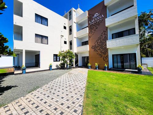 a large white building with a grass yard in front at Lavinia Beach Hotel Ambalangoda in Ambalangoda