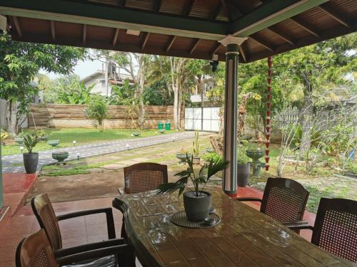 Una mesa y sillas en un patio con vista a un jardín. en Green Relax Villa, en Mirissa