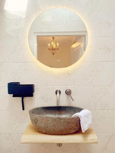 a bathroom with a stone sink and a mirror at La Bastide in Heiloo