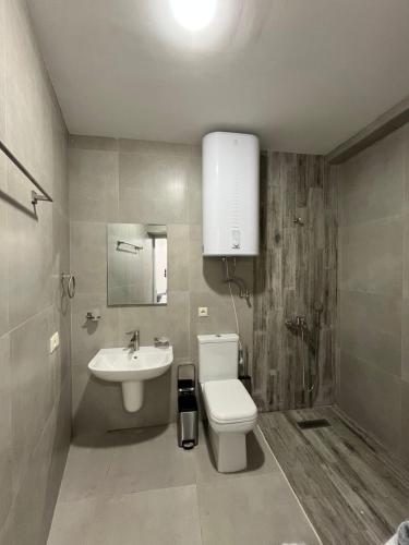 a bathroom with a white toilet and a sink at Harutyunyants Hall in Ijevan