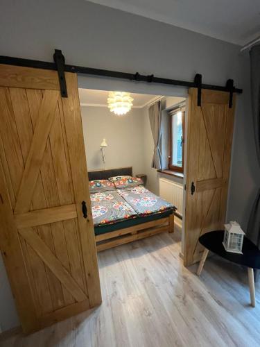 a bedroom with a bed with a wooden door at Beskidzka 25a in Szczyrk