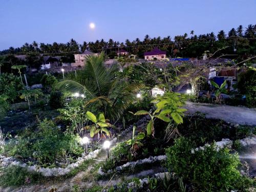 Una vista nocturna de un resort con luces. en GHhome Zanzibar, en Pingwe