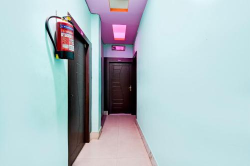 a hallway with purple ceilings and a black door at Hotel O Elixir in Dohāri