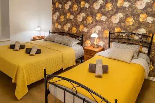 a bedroom with two beds with yellow sheets at Old Town Luxury 2 Bedroom Suite 65 m2 on 3rd floor in Tallinn