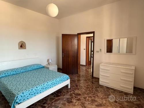 een slaapkamer met een bed en een ladekast bij Villetta Mirion in Marina San Gregorio