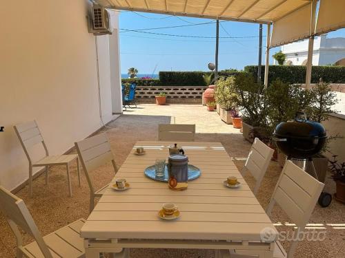 een houten tafel en stoelen op een terras bij Villetta Mirion in Marina San Gregorio