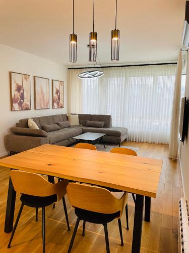 a living room with a wooden table and chairs at Dinka Apartments Park Lake in Tuzla