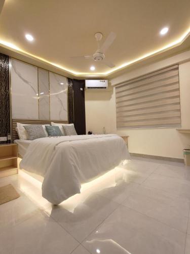 Royal Village في دانجيثي: غرفة نوم بسرير أبيض كبير مع أضواء LED