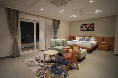 a hotel room with a bed and a couch at Kolas Grand - Hotel and Convention Center in Warangal