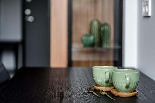 two green cups sitting on top of a table at Modern Urban loft in Vilnius
