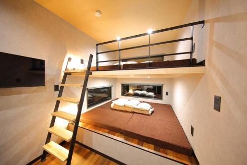 Un dormitorio con una litera y una escalera. en Fuji Time Traveler BBQが楽しめる 河口湖湖畔すぐそば 6名宿泊可のトレーラーハウス, en Azagawa