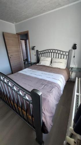a bedroom with a large bed with a metal frame at Jagersrust aan zee in Blankenberge