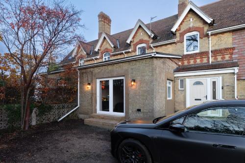 Luxury Suite with Jacuzzi Bath for Two في Isle of Wight: سيارة متوقفة أمام منزل من الطوب