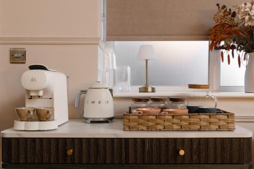 Luxury Suite with Jacuzzi Bath for Two في Isle of Wight: طاولة مطبخ مع آلة صنع القهوة وسلة من الطعام