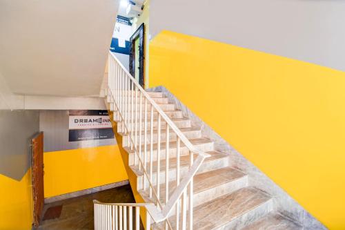 a staircase in a building with a yellow wall at Hotel O Elixir in Dohāri