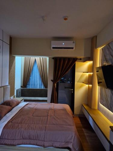 a bedroom with a large bed and a window at Alton City Loft in Jatingaleh