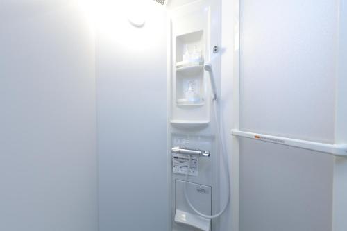 Un refrigerador con la puerta abierta en una habitación. en Fuji Time Traveler BBQが楽しめる 河口湖湖畔すぐそば 6名宿泊可のトレーラーハウス, en Azagawa