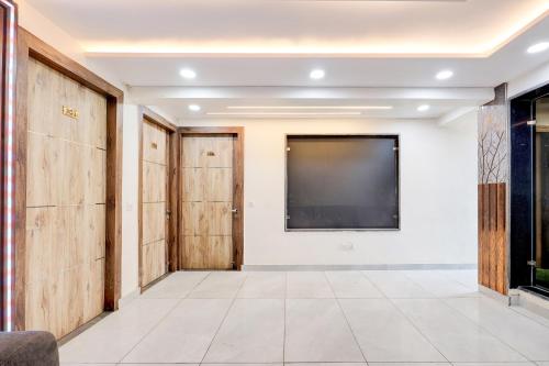 Una gran sala con puertas de madera y una pantalla de proyección. en Hotel O Shalimar, en Ghaziabad