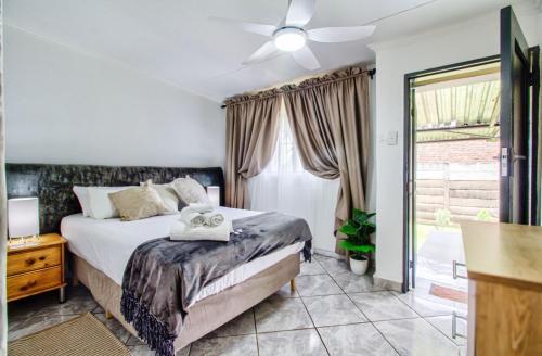 Peaceful luxurious fully-equipped home في سنتوريون: غرفة نوم بها سرير ومروحة سقف