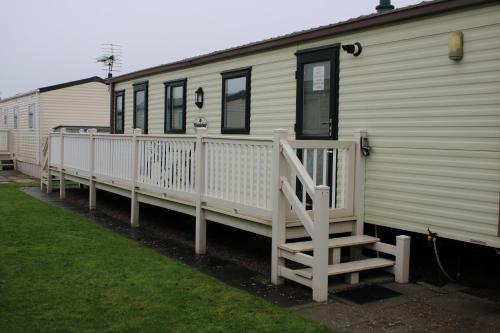 a white mobile home with a porch and a staircase at Annandale skegness in Skegness