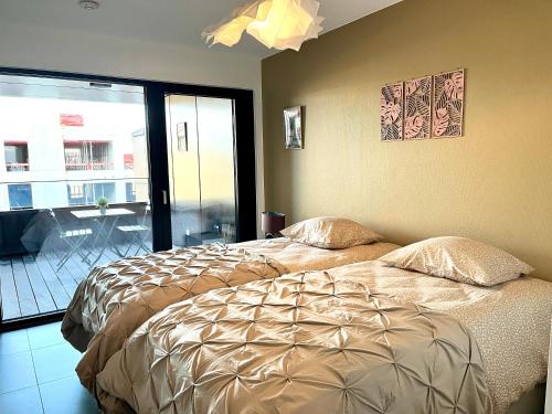 a bedroom with a bed and a large window at La Loggia - Appartement Terrasse Esch Belval in Esch-sur-Alzette