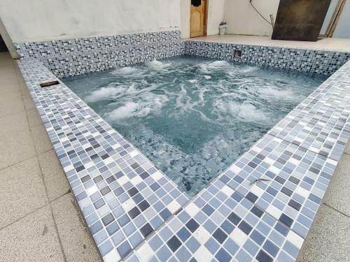 jacuzzi con azulejos azules y blancos en Coney Camping, en Ambato