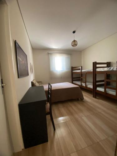 a small room with two bunk beds and a desk at Casa Star - Vista para as Montanhas in Monte Sião