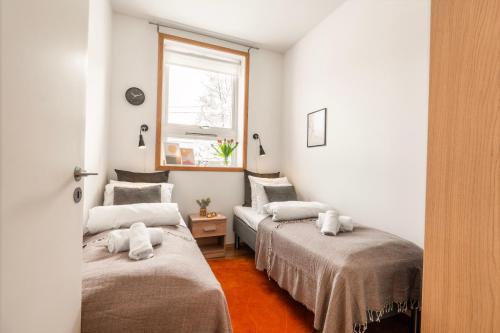 two beds in a room with a window at Tromsø Town and Nature in Trondalen