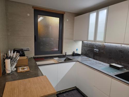 a kitchen with white cabinets and a window at Casa dos sonhos em Vale do Lobo in Loulé