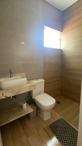 a bathroom with a white toilet and a sink at Casa Star - Vista para as Montanhas in Monte Sião