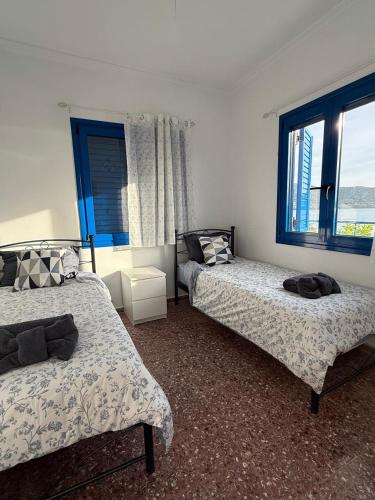 a bedroom with two beds and a window at Marina Helios Home in Áyios Yeóryios