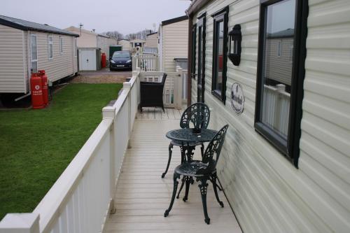 a patio with two chairs and a table on the side of a house at Annandale skegness in Skegness