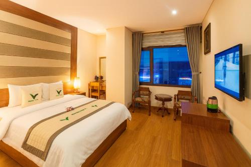 a hotel room with a large bed and a window at Moonlight Hotel & Apartment - High Floor, panoramic views of the city and river, Dragon Bridge in Da Nang