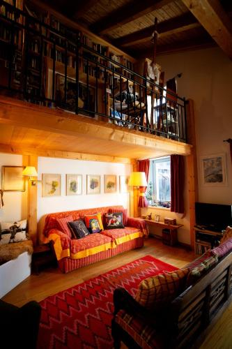 a living room with a couch and a balcony at Chesa Principela - La Punt in La Punt-Chamues-ch