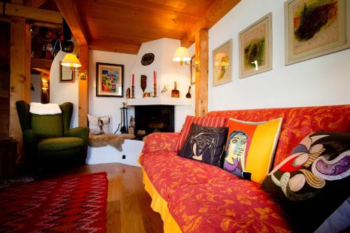 Una sala de estar con un sofá rojo y una silla. en Chesa Principela - La Punt, en La Punt-Chamues-ch