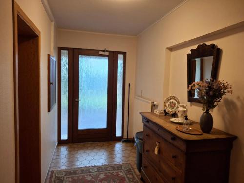 a room with a door and a dresser with a mirror at Guesthouse Les Tilleuls in Fleurus