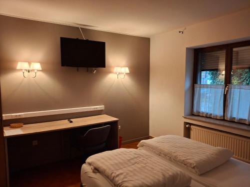 a bedroom with a bed and a desk and a television at Guesthouse Les Tilleuls in Fleurus