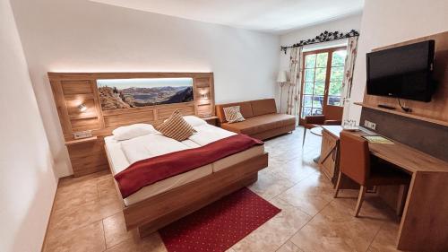 シュトローブルにあるHotel Garni Pension zur Wachtのベッドと机とテレビのある寝室