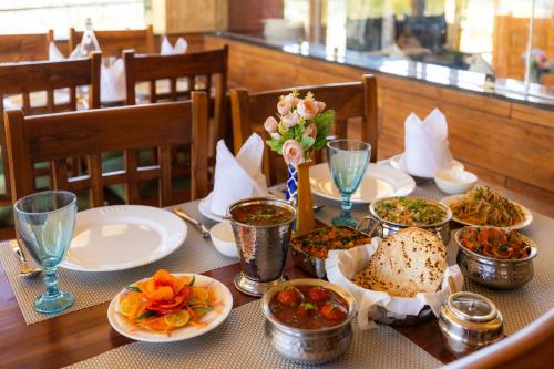 een tafel met borden en kommen met eten erop bij Mary Chalet shanag manali near nehru kund 4 km from mall road in Rahla