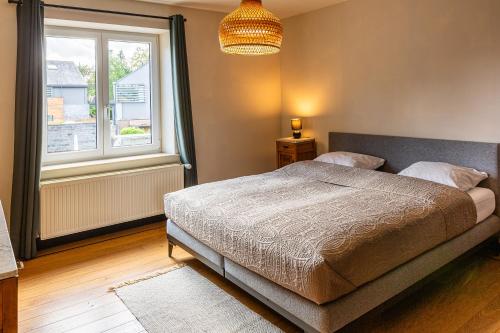 a bedroom with a bed and a large window at Villa Basse Cour in Durbuy