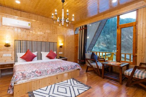 een slaapkamer met een bed, een tafel en stoelen bij Mary Chalet shanag manali near nehru kund 4 km from mall road in Rahla