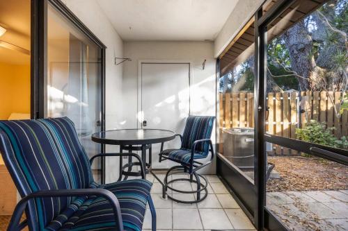 a patio with two chairs and a table on a balcony at Beach Townhome Steps from Downtown Cocoa Beach in Cocoa Beach