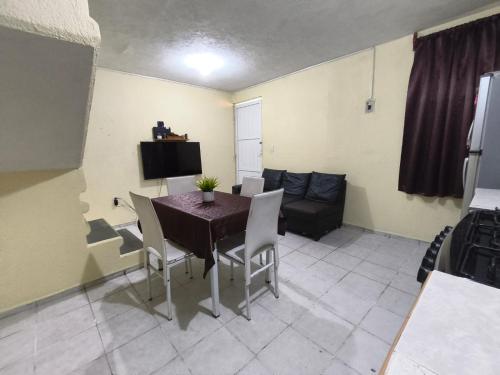 a dining room with a table and chairs and a couch at Casa confortable cerca de FORUM in Coatzacoalcos